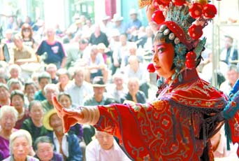 圖為8月15日戲曲演員在“流動舞臺車”上表演傳統(tǒng)地方戲《穆桂英下山》。