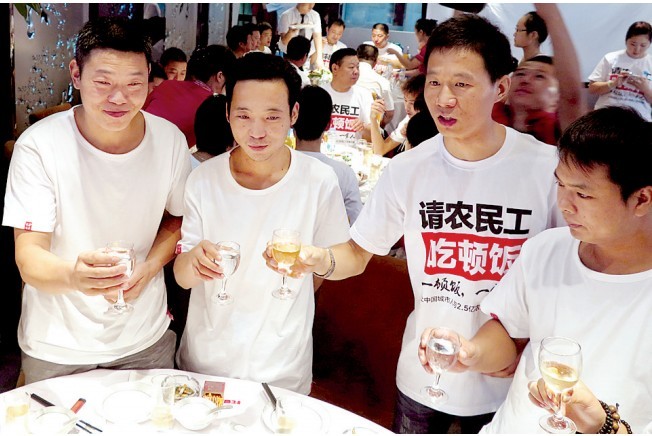 活動(dòng)發(fā)起人張楠（右二）給農(nóng)民工敬酒。