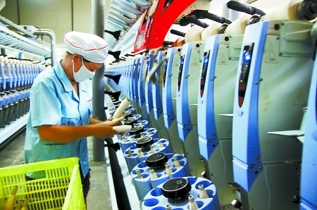7月3日，在鄧州市永泰棉紡有限公司電腦控制全自動紡紗車間，紡織工人正在生產(chǎn)棉紗。