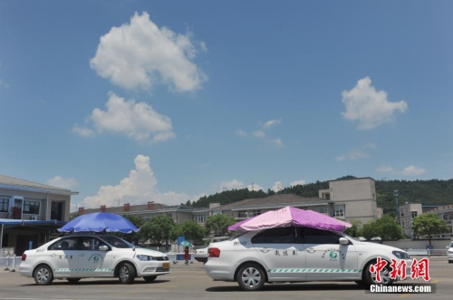 杭州一駕校現(xiàn)遮陽(yáng)新招 教練車(chē)車(chē)頂撐傘