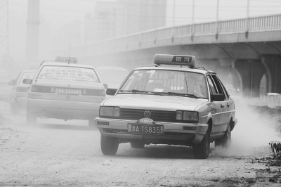 施工的道路上，車輛通過塵土飛揚。