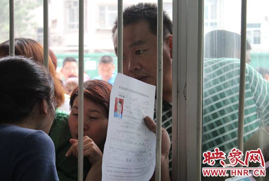 不少家長擠在報名窗口前咨詢報名事宜。