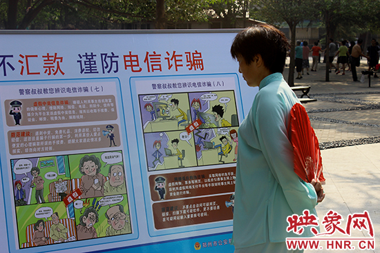 鍛煉的老人在看防詐騙宣傳板