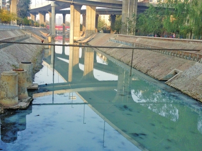 河?xùn)|側(cè)的污水管道正向河里排污水