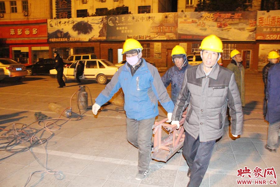 23點56分，第一塊兒廣告牌已經(jīng)分割完畢，地面上的20多名工人將拆除下來的鋼件撞車運走。