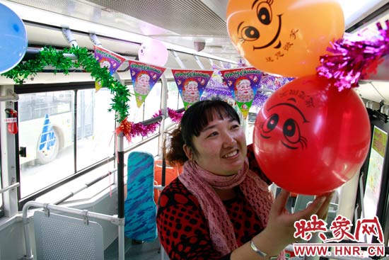 鄭州快速公交B3區(qū)間線車長李鵬云在車廂里懸掛氣球，布置圣誕車廂，營造歡樂圣誕氛圍