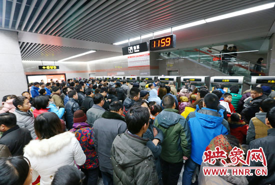 地鐵開通首日，上午十一點五十九分，紫荊山地鐵站售票機前擠滿了買票的市民。