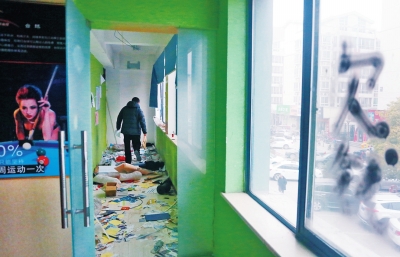　健身會所地上一片狼藉，玻璃上噴著黑色“欠錢”二字。