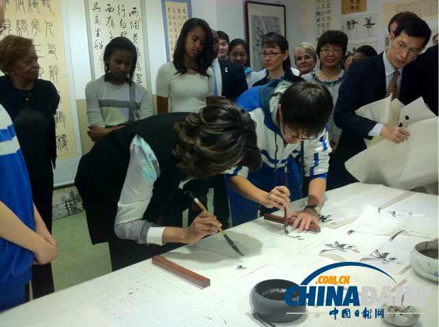 　北京時間3月21日，美國第一夫人米歇爾參觀北師大二附中時，與學(xué)生一起練習(xí)書法。