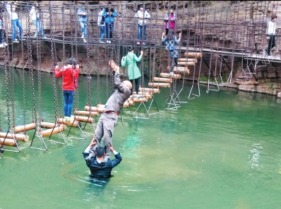 中年男游客正踩著景區(qū)安全員郭小明的肩膀過河。網(wǎng)友“@我的小名叫張孩”供圖