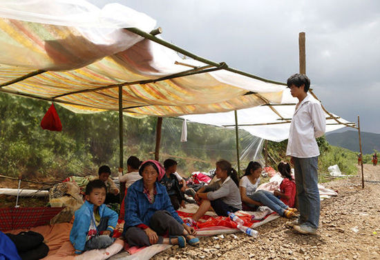 暴雨馬上來(lái)臨，村民們?cè)诤?jiǎn)易帳篷下躲雨。澎湃新聞 程藝輝 圖