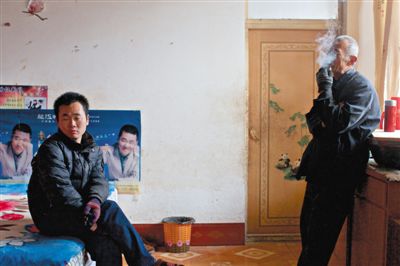 父親抽煙，兒子不語。逃跑的越南新娘，給袁迎賓父子帶來的是失落。新京報記者