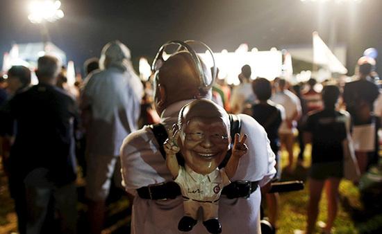 9月4日，新加坡，執(zhí)政黨的一場集會上，一名支持者背著一個李光耀的人偶。