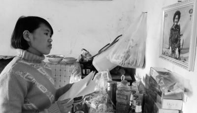 錢仁鳳站在母親遺像前。未能見母親最后一面是她的一大遺憾。