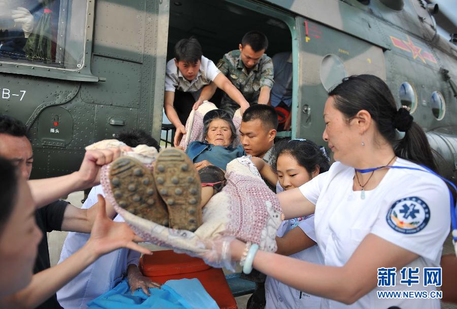 8月5日，醫(yī)護人員將一名通過直升機從震中轉運出來的傷員運下飛機。