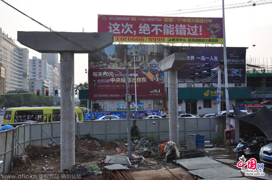 過街天橋一側(cè)的橋樁早已打好,可是對面的郵政銀行網(wǎng)點依舊在照常營業(yè)。