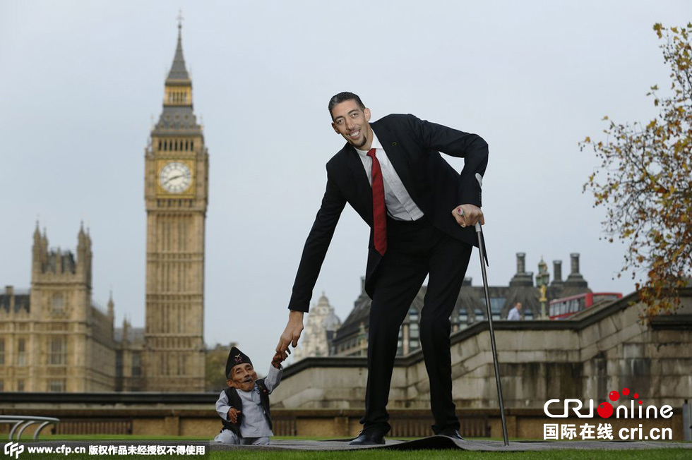 當地時間2014年11月13日，英國倫敦，世界上最矮的男子錢德拉·巴哈杜爾·唐吉與世界上最高的男子蘇