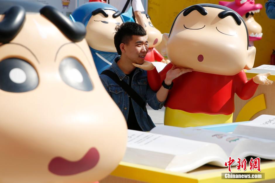 4月22日，游客與蠟筆小新合影?！跋灩P小新25周年紀(jì)念特展”日前在北京開展，吸引了不少市民游客。
