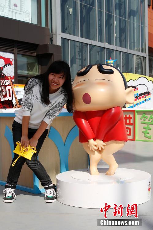 4月22日，游客與蠟筆小新合影?！跋灩P小新25周年紀(jì)念特展”日前在北京開展，吸引了不少市民游客。