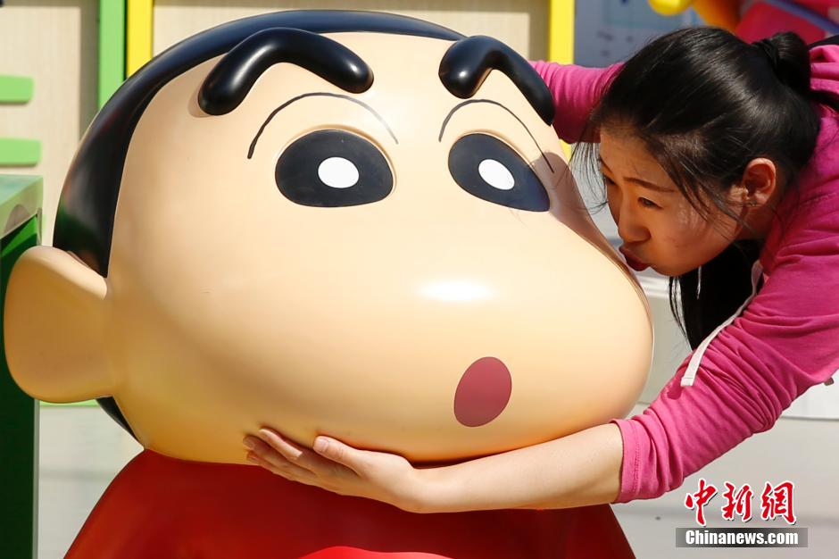 4月22日，游客與蠟筆小新合影?！跋灩P小新25周年紀(jì)念特展”日前在北京開展，吸引了不少市民游客。