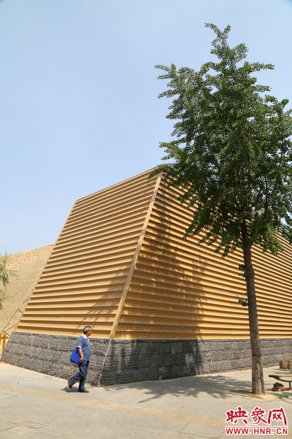 一名路人從“土豪金”保護(hù)殼前經(jīng)過。