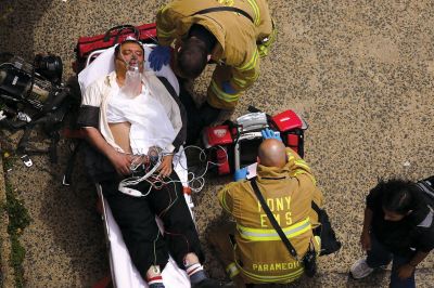 2日，救援人員在美國(guó)紐約地鐵事故車輛內(nèi)緊急疏散一名受傷乘客。圖/CFP