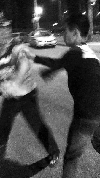 一名男子扯著民警的反光背心一路追打。