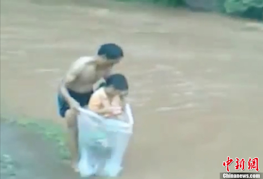 越南一村莊家長(zhǎng)用塑料袋運(yùn)孩子過河上學(xué)