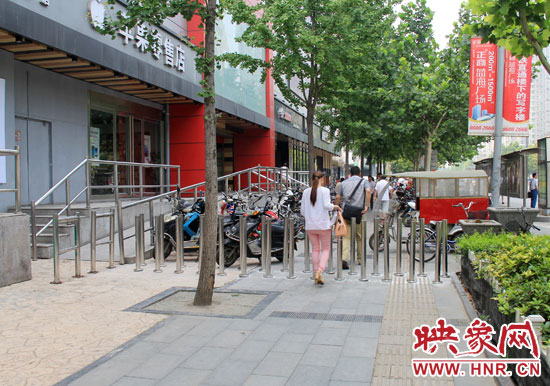 圖中道路左側(cè)的無障礙通道被鋼管隔離,右側(cè)的盲道也被侵占。