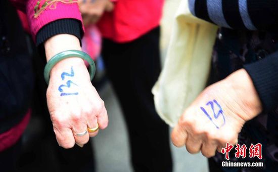 圖為10月28日，在江西九江市一家羊絨皮草服裝服飾博覽會現(xiàn)場，老人們正在頂著寒風(fēng)排隊(duì)等待領(lǐng)取10元代金劵。