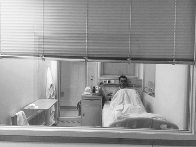 楊杰在醫(yī)院隔離病房中，沖記者揮了揮手。