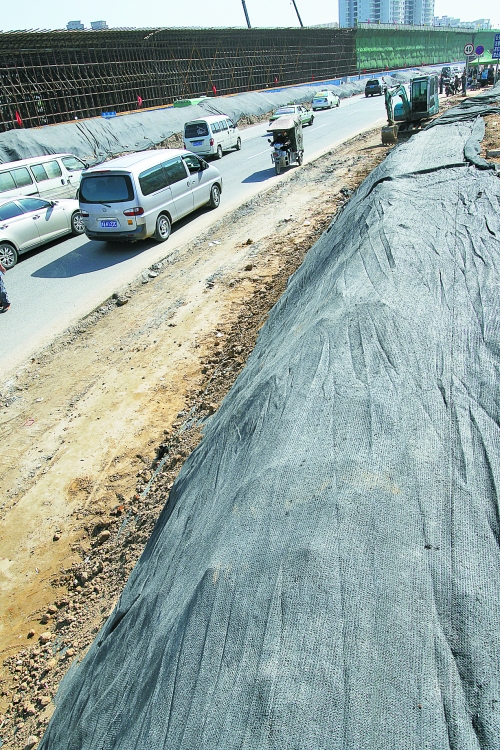 豐樂路與北三環(huán)交叉口，修路的土被歸置得整整齊齊，并用黑網(wǎng)覆蓋，既保暢通又避免了揚(yáng)塵。