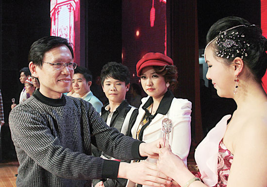 2013年2月1日，《對9當(dāng)歌》總決賽在鄭州開唱。圖為東方今報(bào)副社長胡楊為選手頒獎(jiǎng)