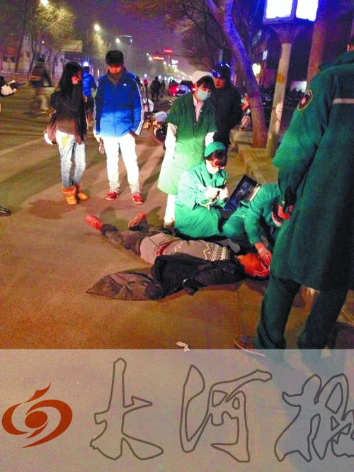 醉漢躺在地上，醫(yī)護(hù)人員對(duì)其進(jìn)行檢查。